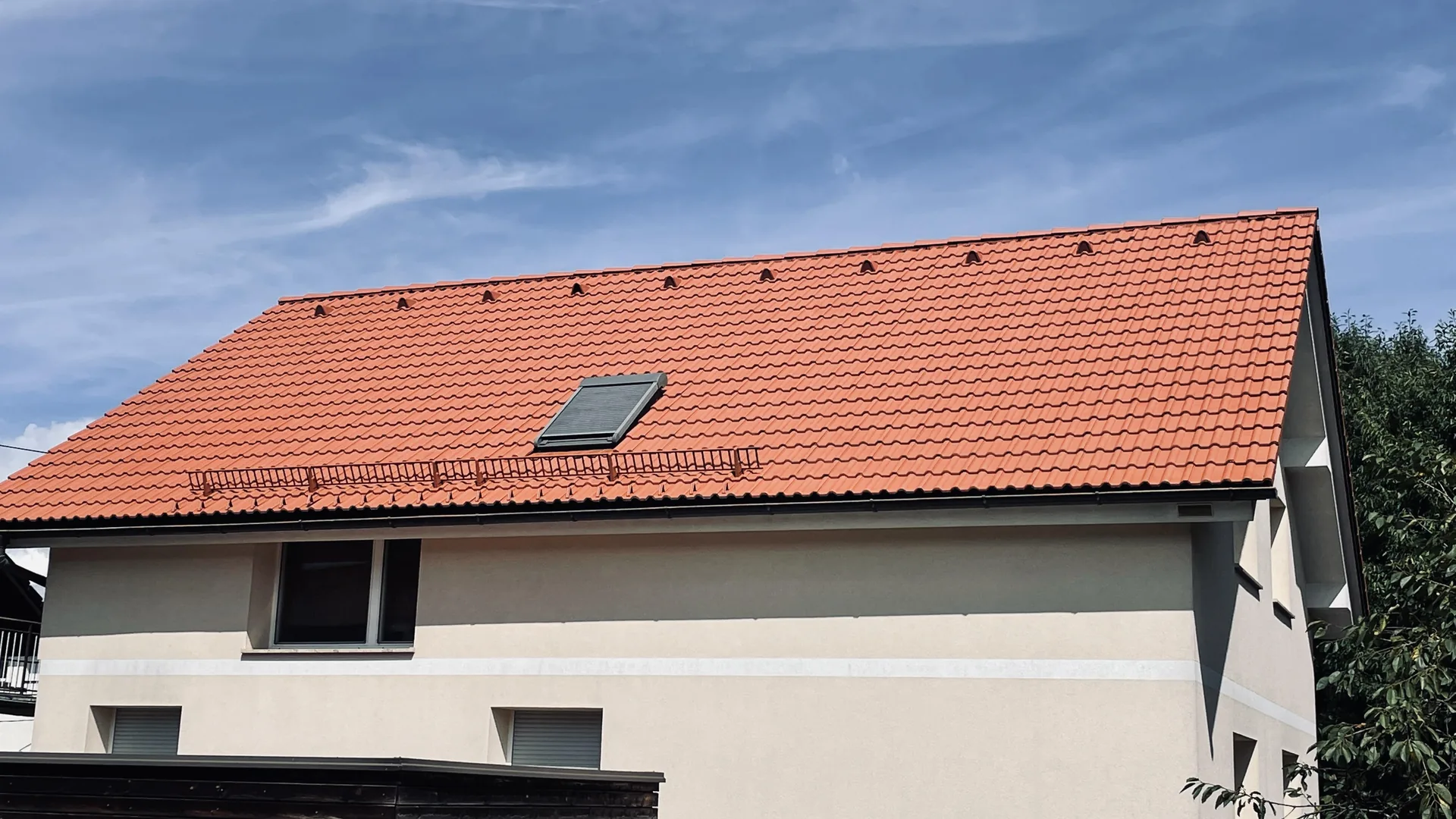 Rdeča streha s strešnim oknom in snegolovi.